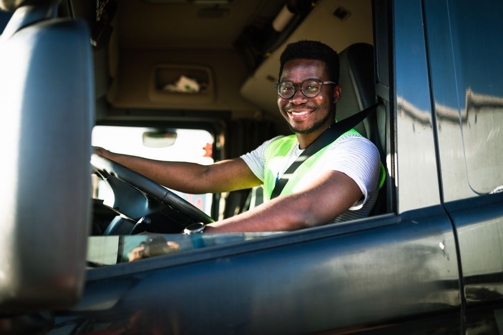 a man is sitting in the driver 's seat of a truck .