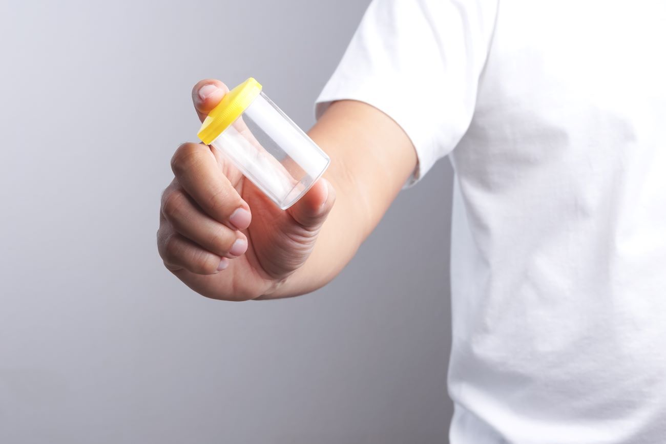 a person is holding a drug & alcohol urine test in their hand.