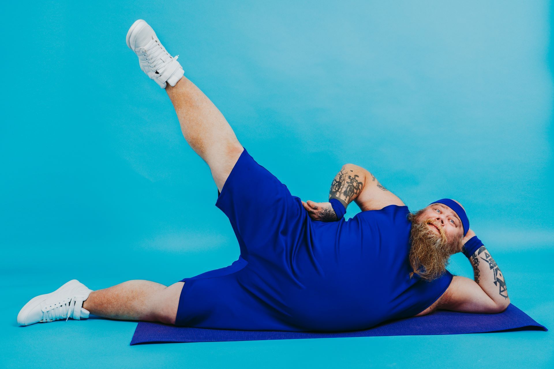 a man is laying on a yoga mat with his leg up .