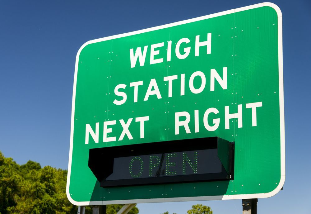 a green sign that says weigh station next right