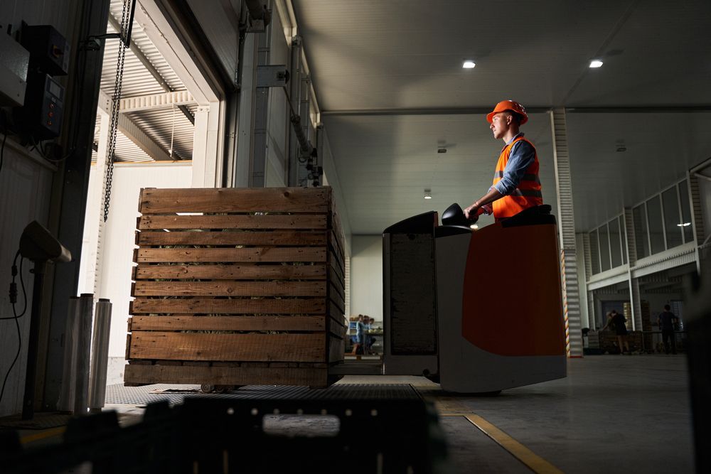 a man is driving a forklift in a warehouse .