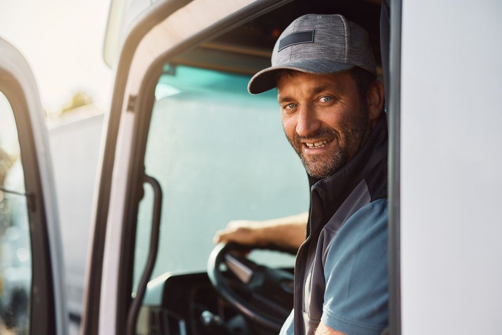 a OTR trucker is sitting in the driver 's seat of a truck.