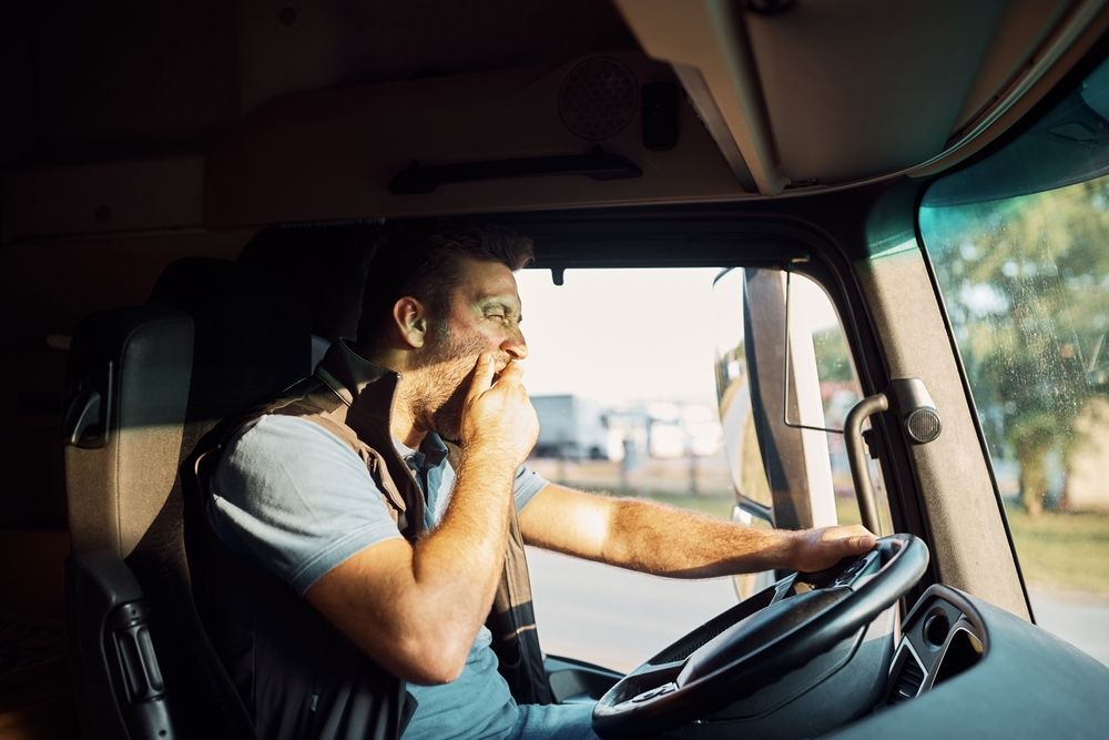 a man is sitting in the driver 's seat of a truck .