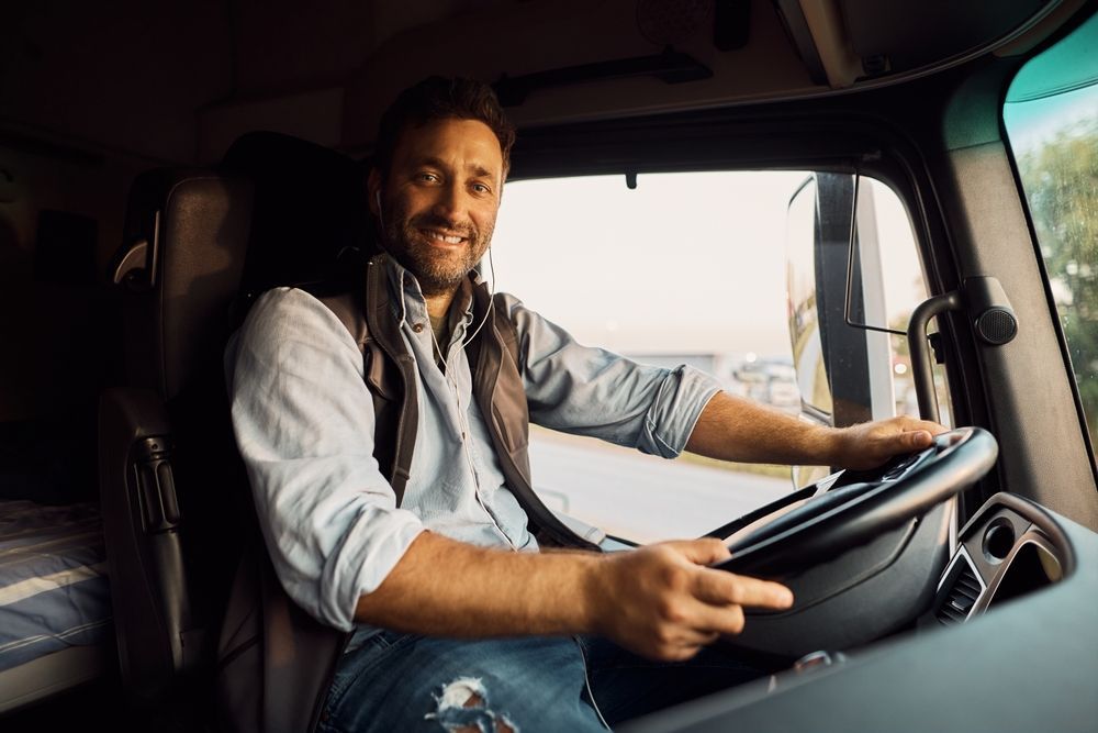 a man is sitting in the driver 's seat of a semi truck .