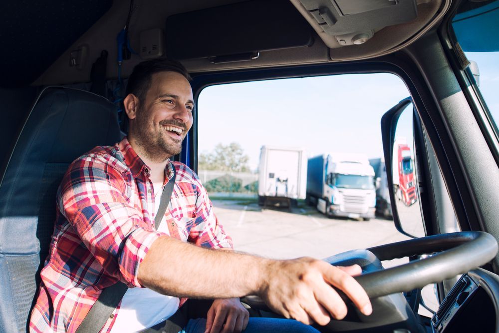 a man is sitting in the driver 's seat of a semi truck .