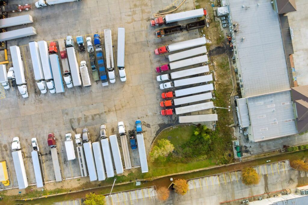 an aerial view of a rest stop filled with trucks and trailers.