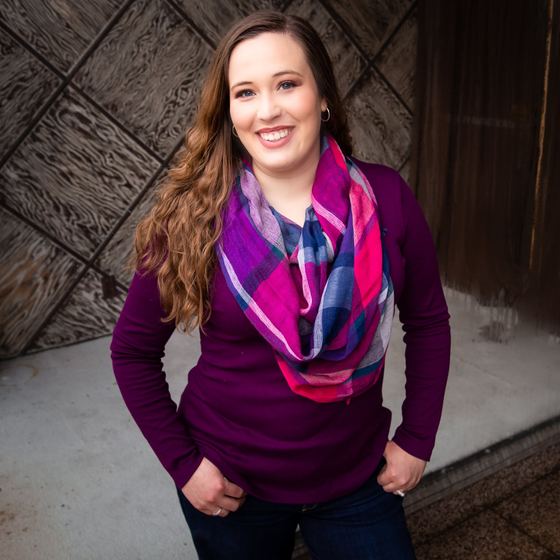 A woman wearing a purple sweater and a purple scarf