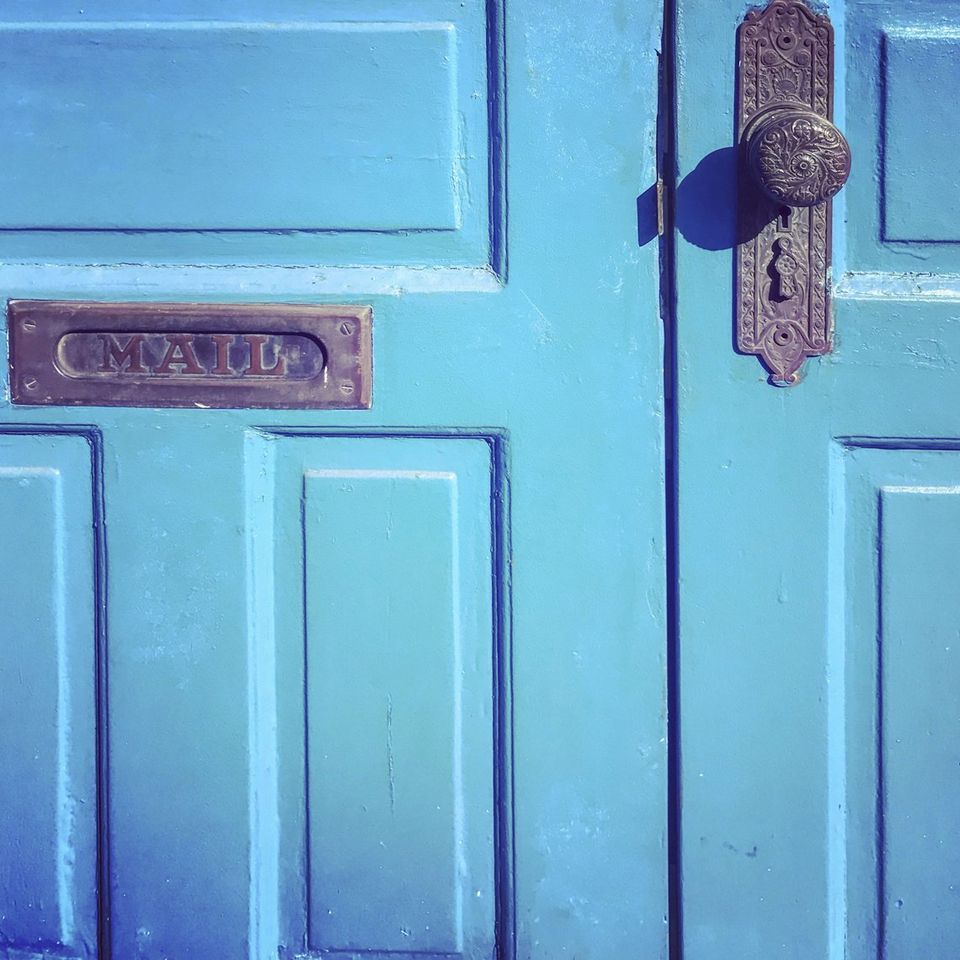 A blue door with a mail slot