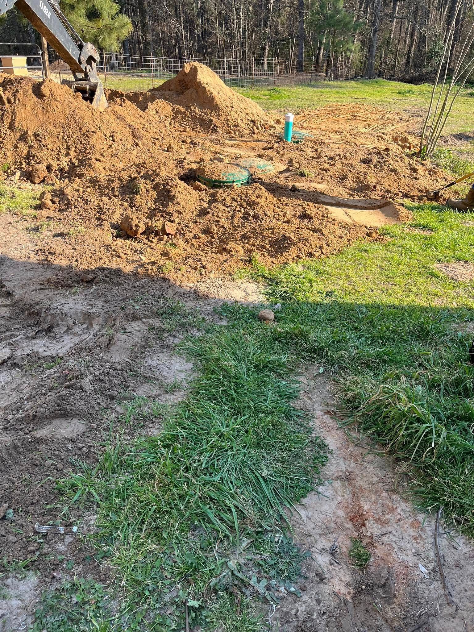 A pile of dirt is sitting on top of a lush green field.