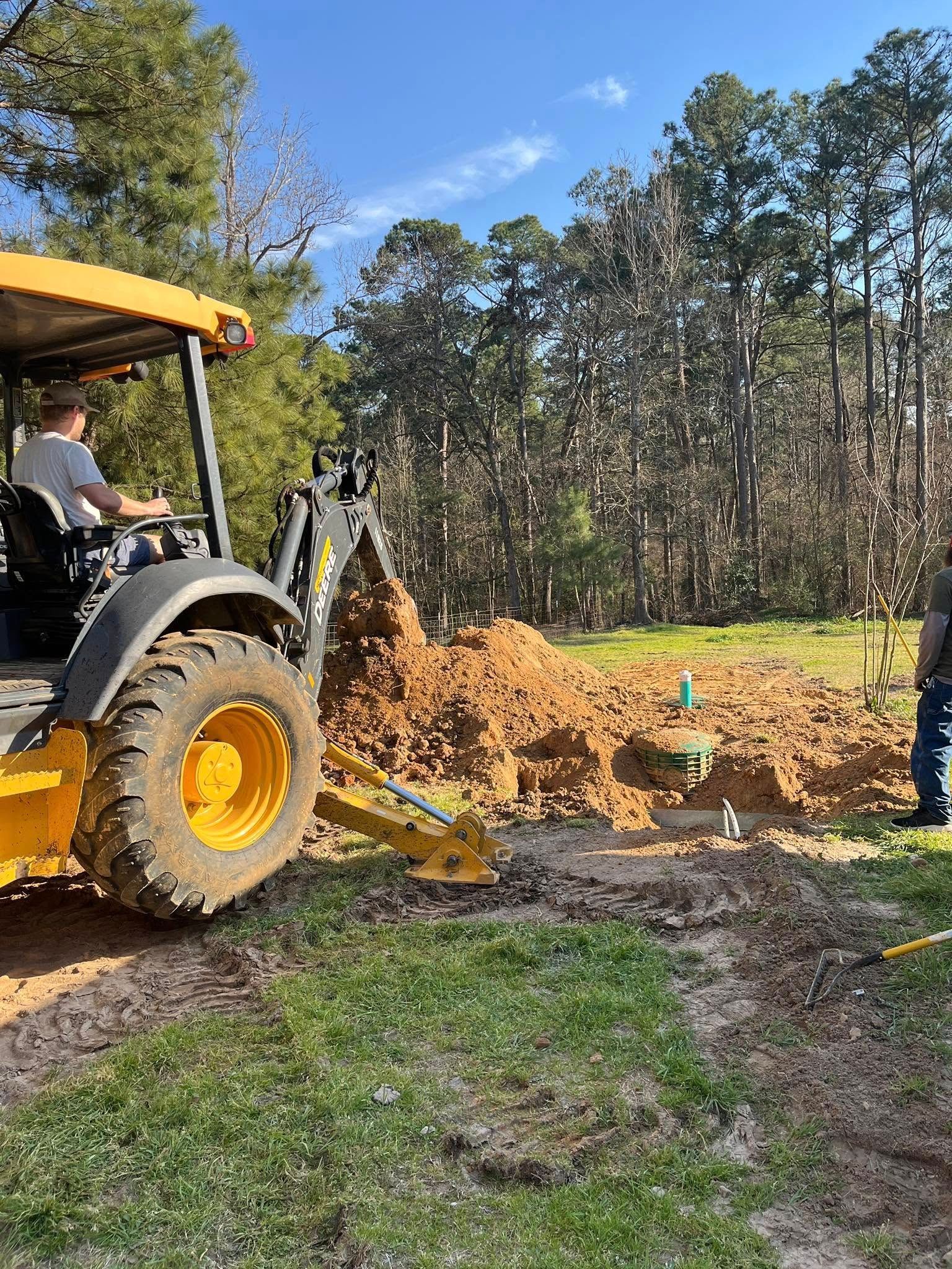 A man is driving a yellow tractor in a field.