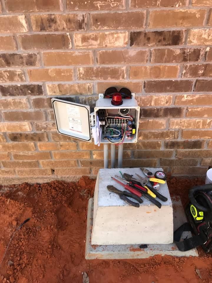 A box with tools inside of it is sitting on top of a brick wall.