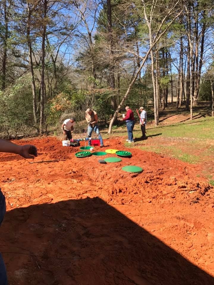 A group of people are playing a game in the dirt.