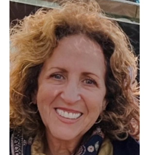 A man wearing glasses and a white lab coat with the name john on it