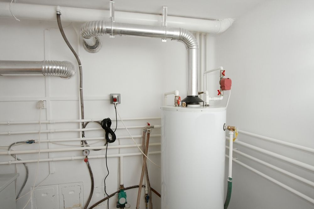 A White Water Heater in A Utility Room with Pipes and Vent Connected to It — Harwood Plumbing & Gasfitting Pty Ltd in Fannie Bay, NT