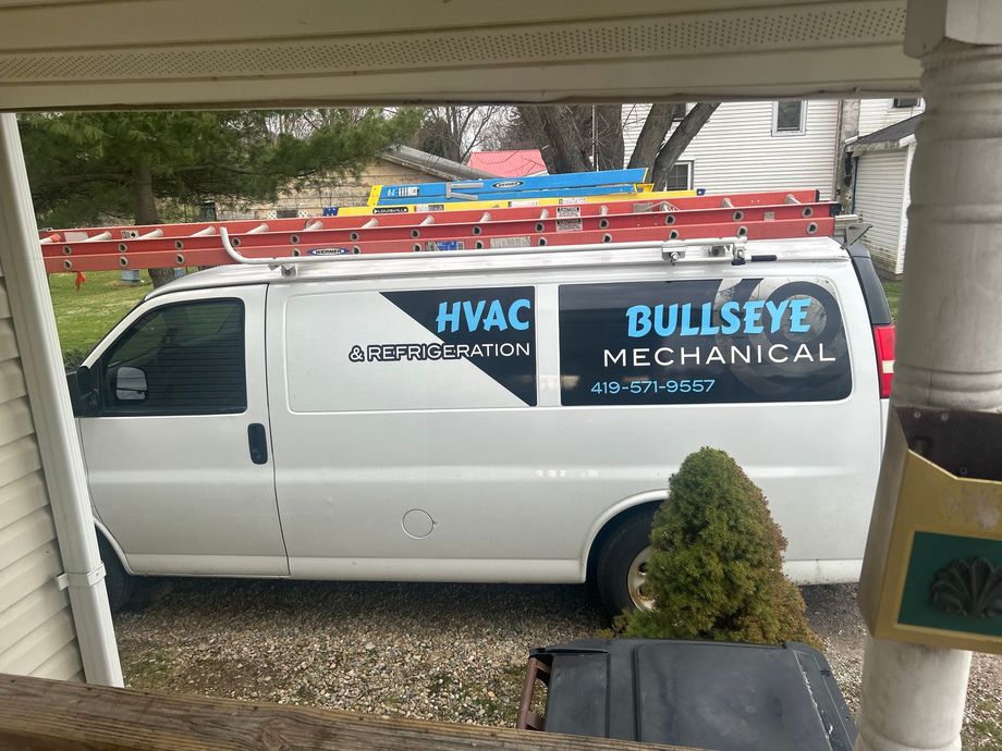 A white work van parked outdoors with 