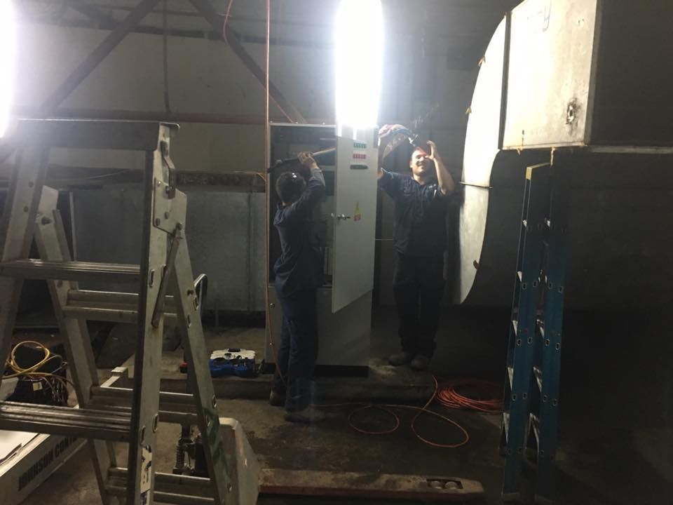 Two Men Are Working on a Machine in a Room With a Ladder — Legit Air Conditioning in Garbutt, QLD