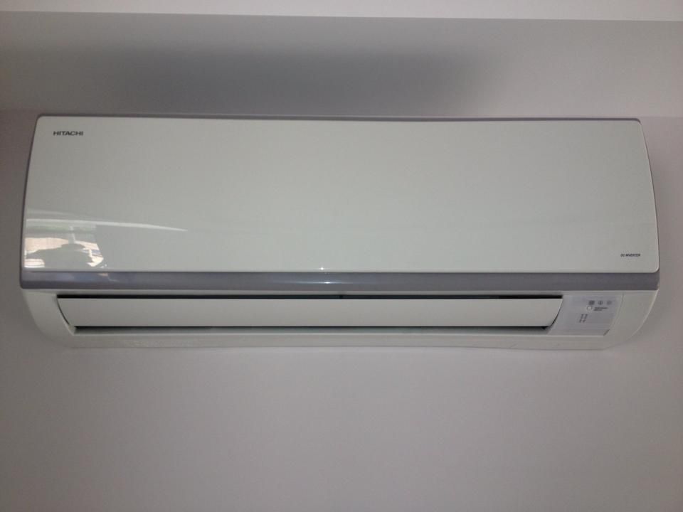 A White Air Conditioner is Hanging on a White Wall — Legit Air Conditioning in Garbutt, QLD