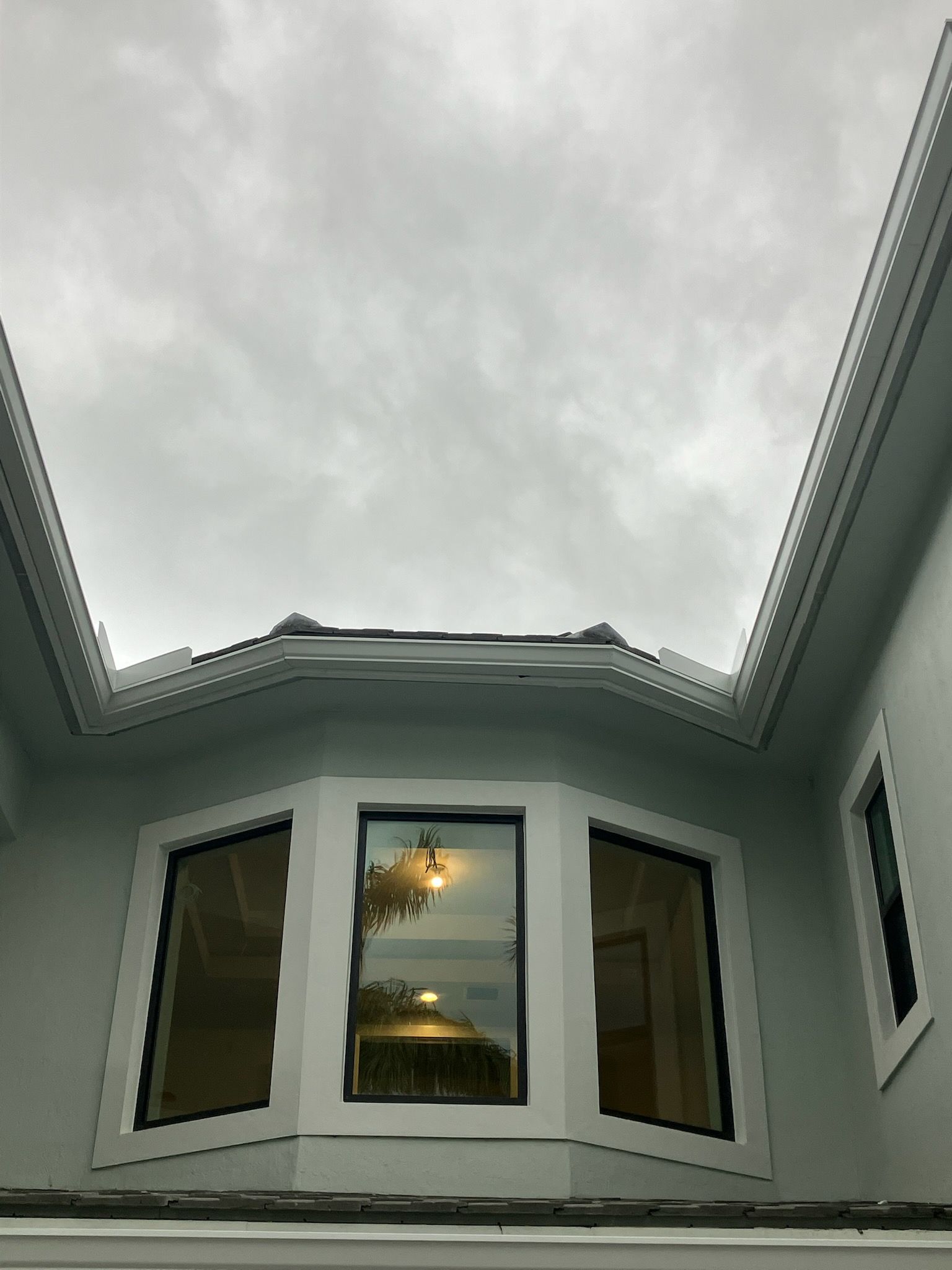 Rainwater overflowing from a roof gutter. Water droplets falling from the edge.