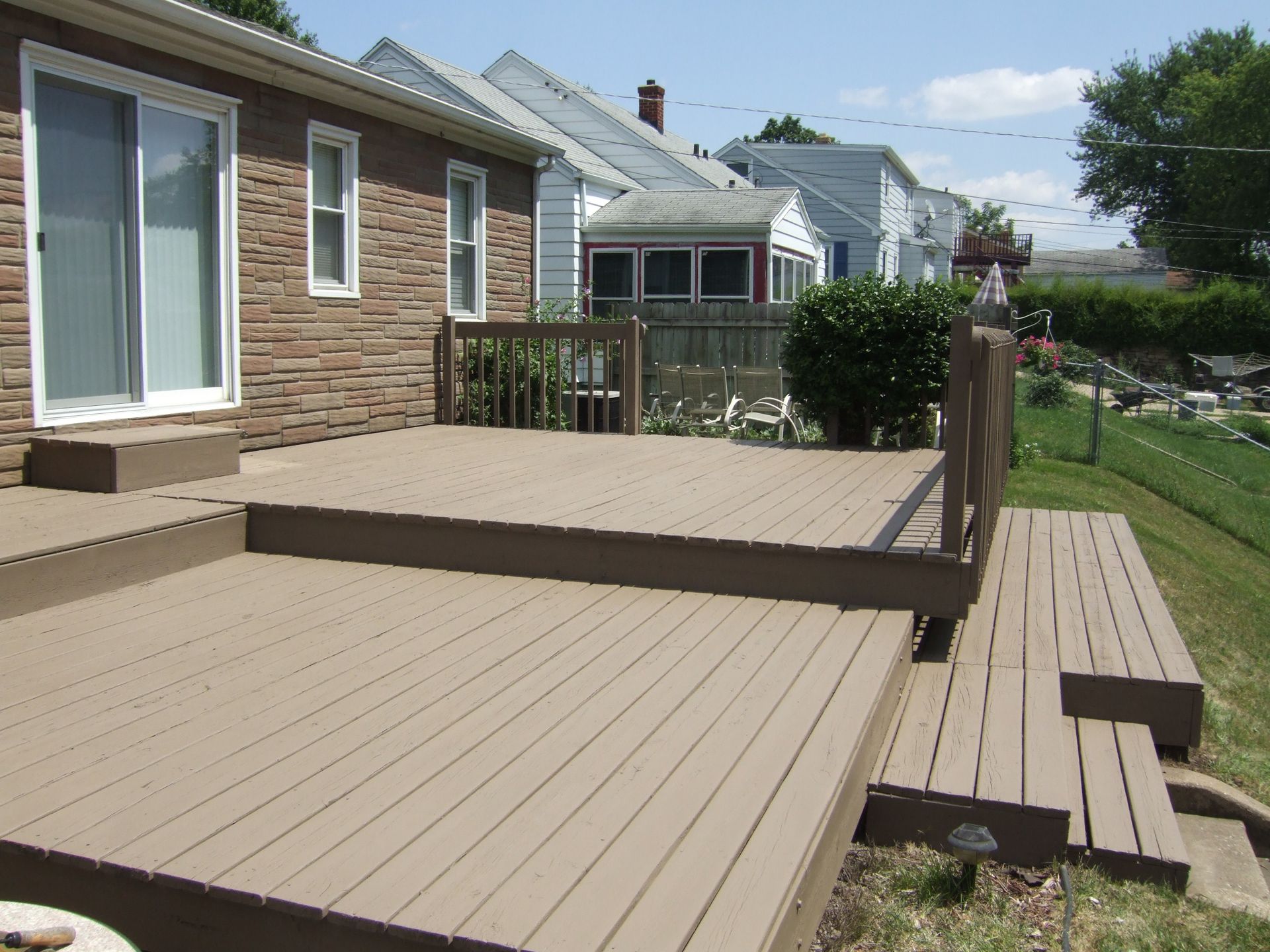 A deck with stairs leading up to it in front of a house