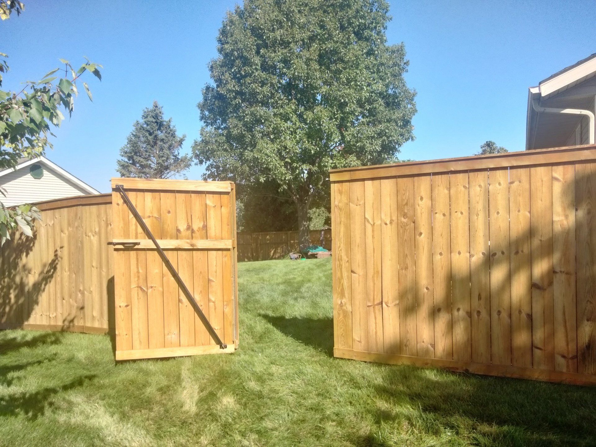 A wooden fence with a gate in the middle of it