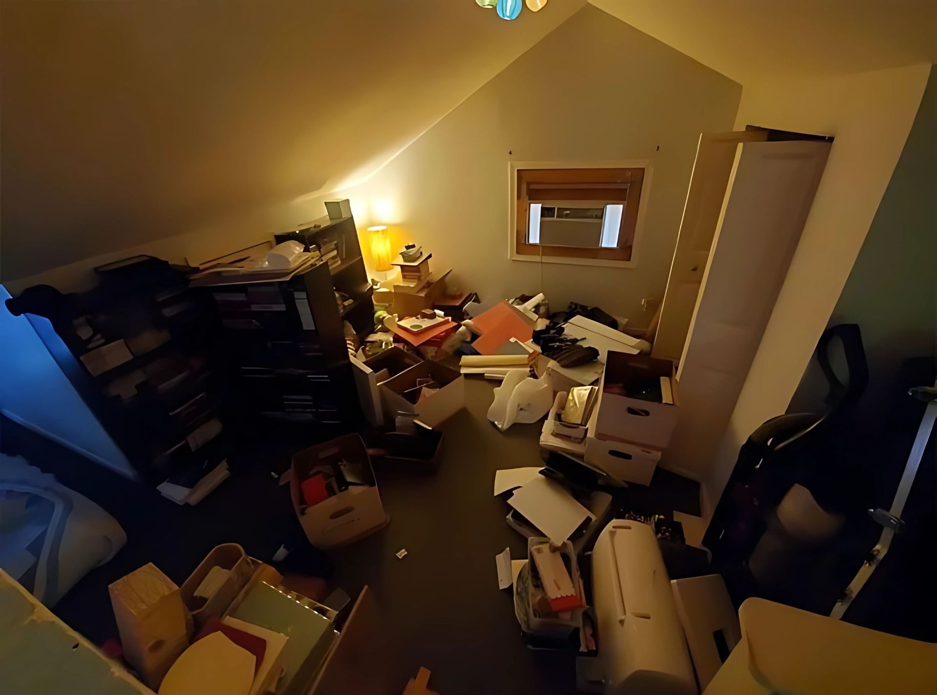 A room with a lot of stuff on the floor and a window