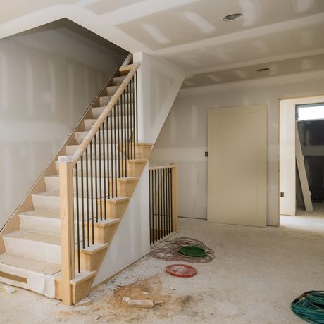 GetReadytoList | A wooden staircase with a metal railing in an empty room