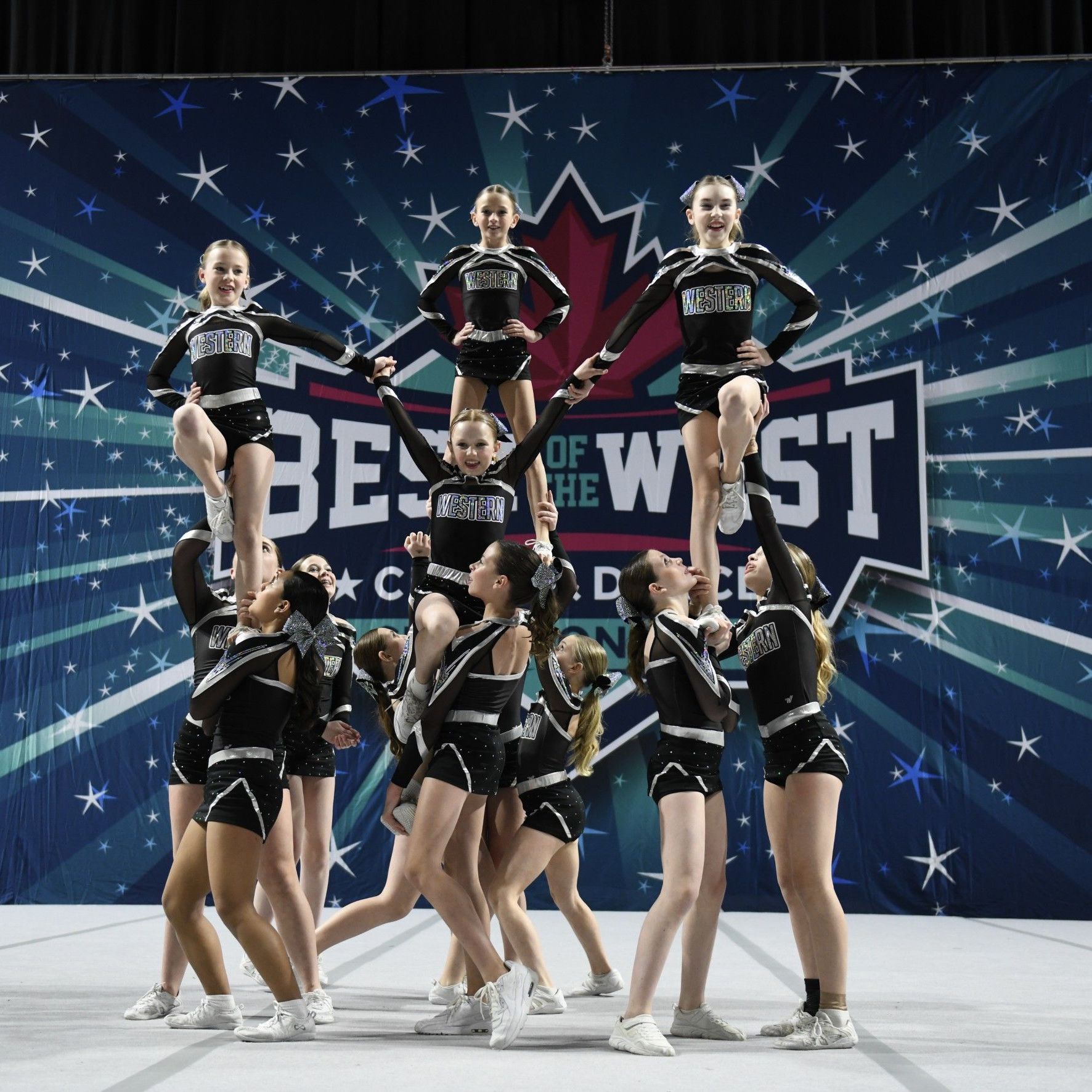 Cheerleaders perform in front of a banner that says best of the west