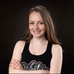 A woman wearing a black tank top with the word white on it