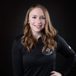 A woman is wearing a black shirt and smiling for the camera.