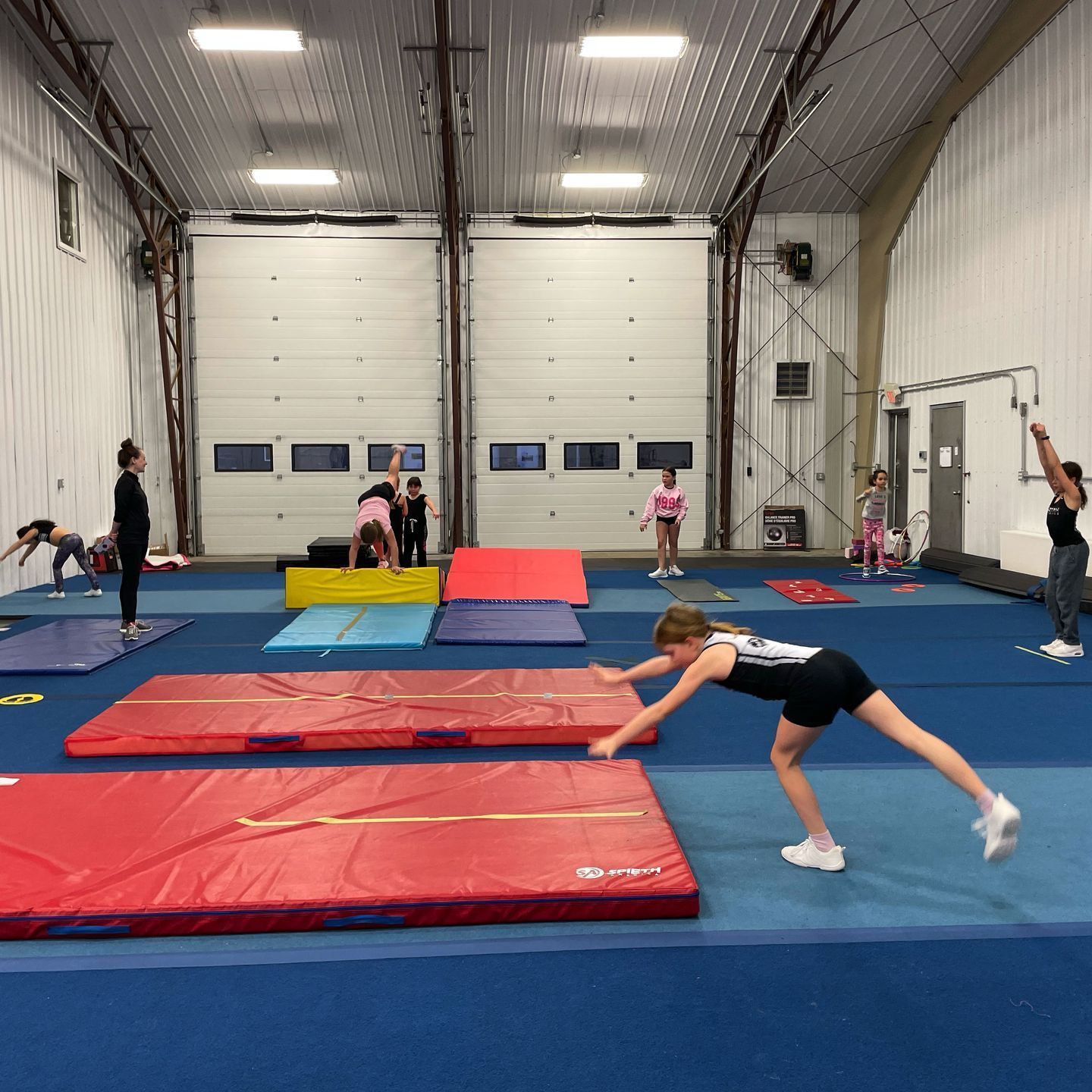 A group of people are doing gymnastics in a gym