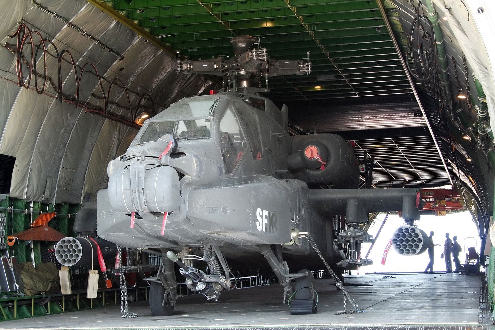 Een militaire helikopter staat geparkeerd in een hangar