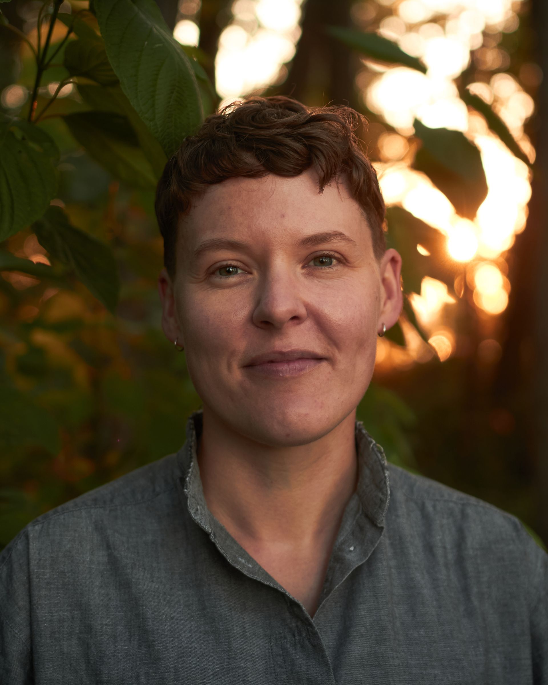 Image of Merle Harley surrounded by plants and leaves