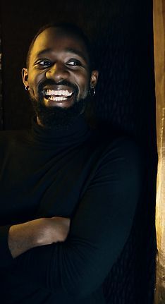 Image of Ziza Patrick smiling in front of a plain background