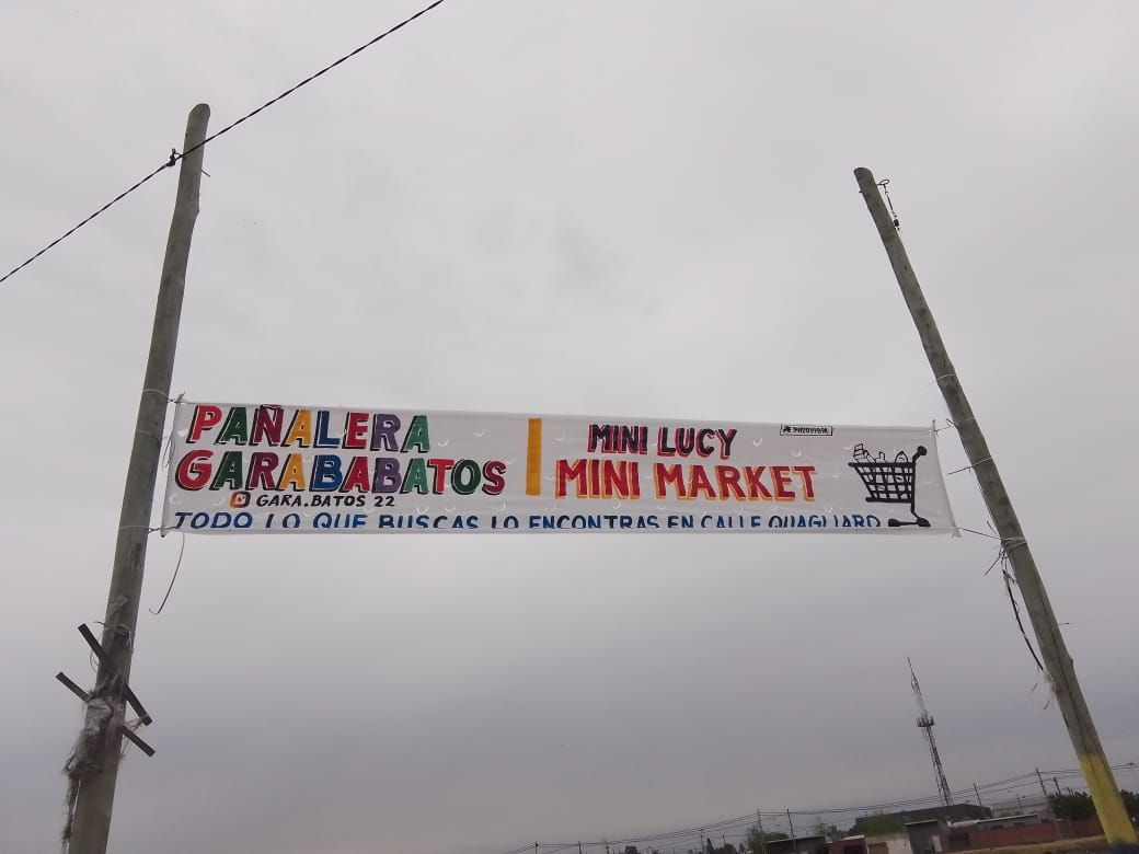 Un cartel del minimercado Panalera Garabatos cuelga de un poste.
