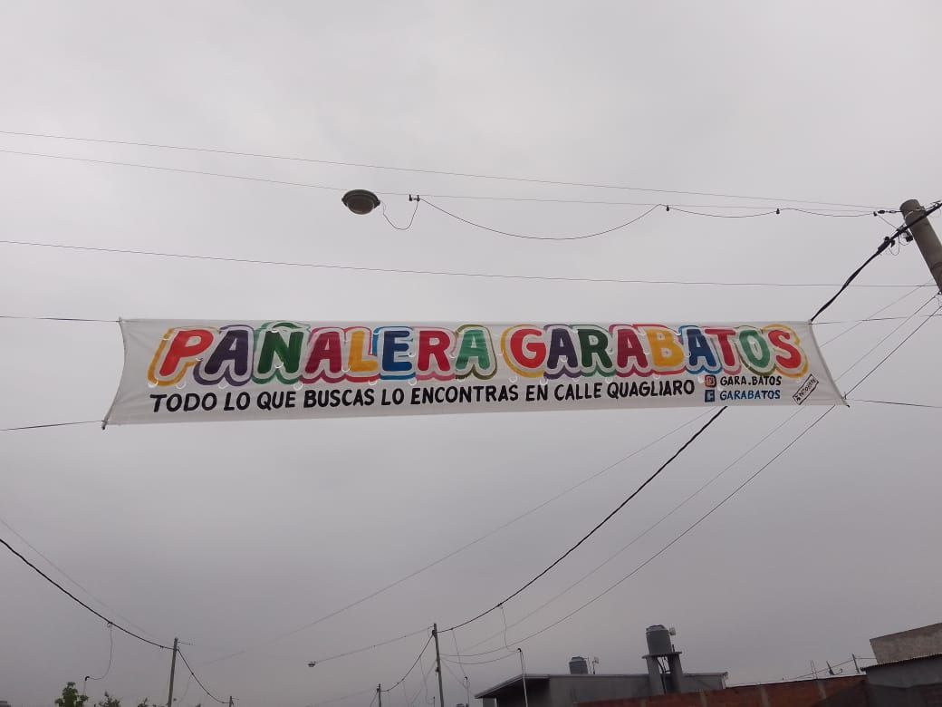 Una pancarta colgada de un cable eléctrico que dice 