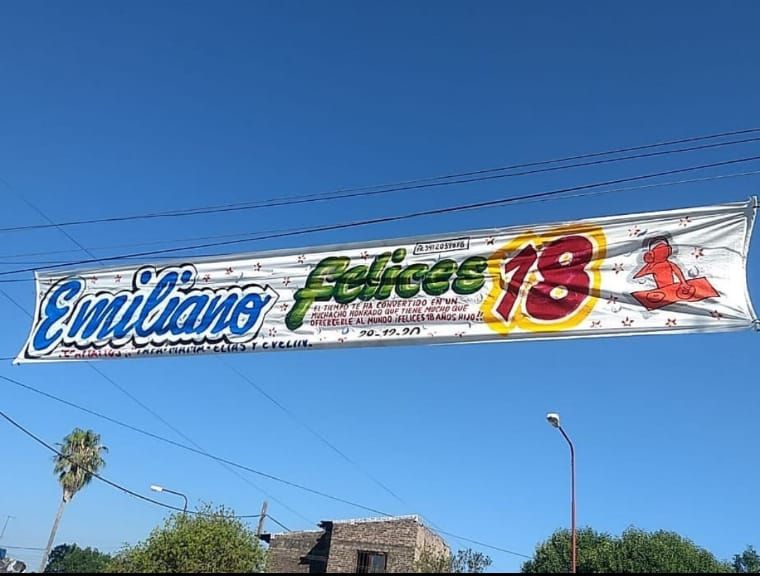 Una pancarta colgada de un cable eléctrico que dice Emiliano Felices 18