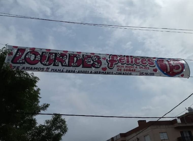 Una pancarta que dice Lourdes felices cuelga sobre una calle
