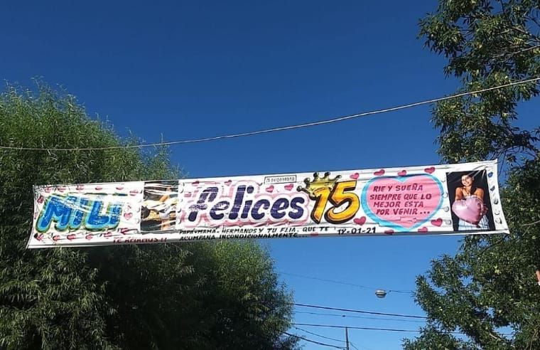 Una pancarta colgada de cables eléctricos que dice felices 15