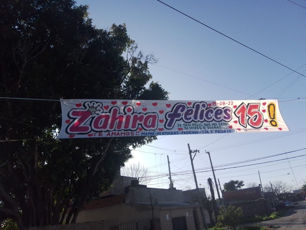 Una pancarta que dice Zahira Felices 15 cuelga de un poste