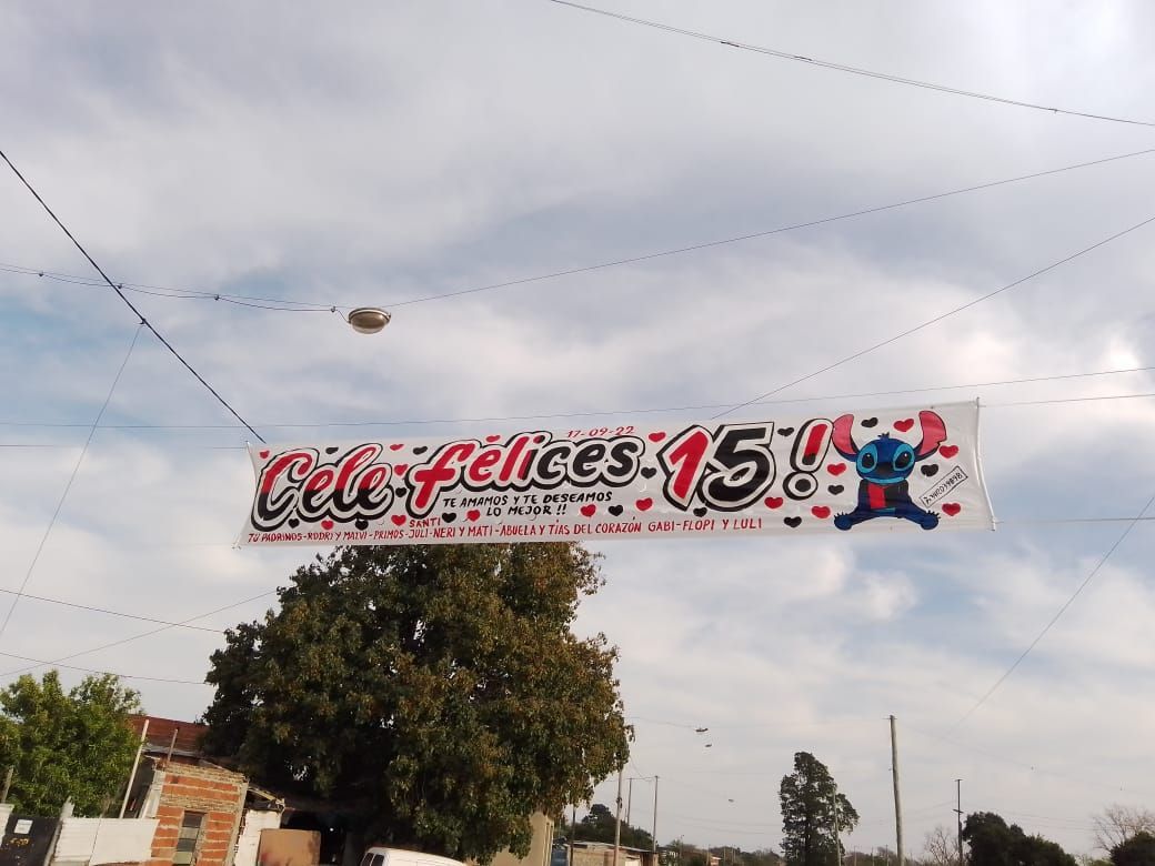Una pancarta colgada de un cable eléctrico que dice Cielo Feliz 15