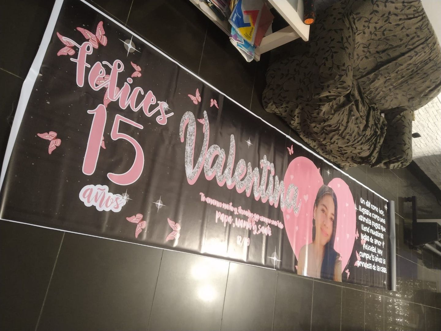 Una gran pancarta está en el suelo al lado de un sofá.