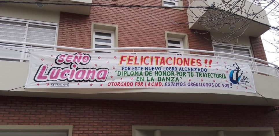 Un edificio con una pancarta que dice felicitaciones.