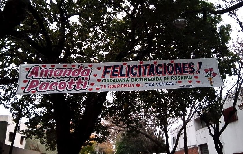 Una pancarta colgada de un árbol que dice felicitaciones