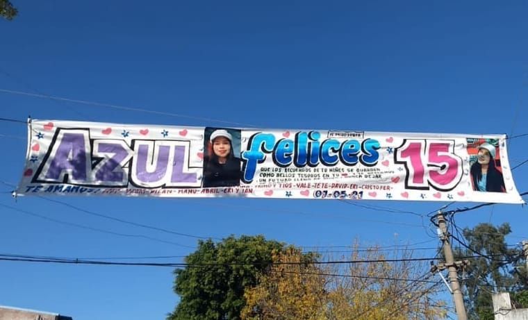 Una pancarta que dice Azul Felices 15 está colgada de un cable eléctrico.