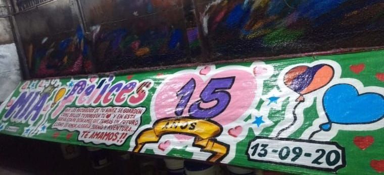 Un cartel verde y rosa con globos y corazones.