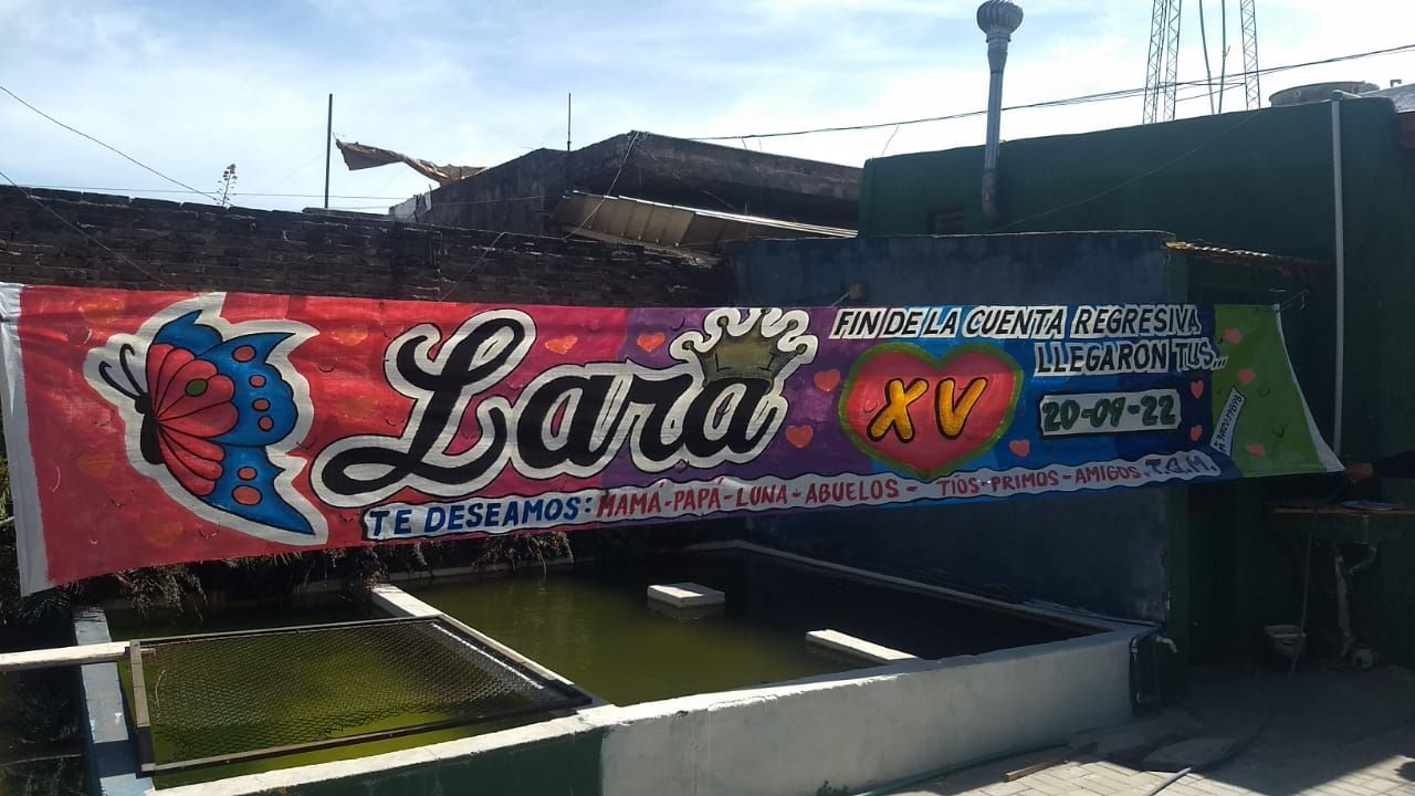 Una gran pancarta colorida cuelga sobre un estanque.