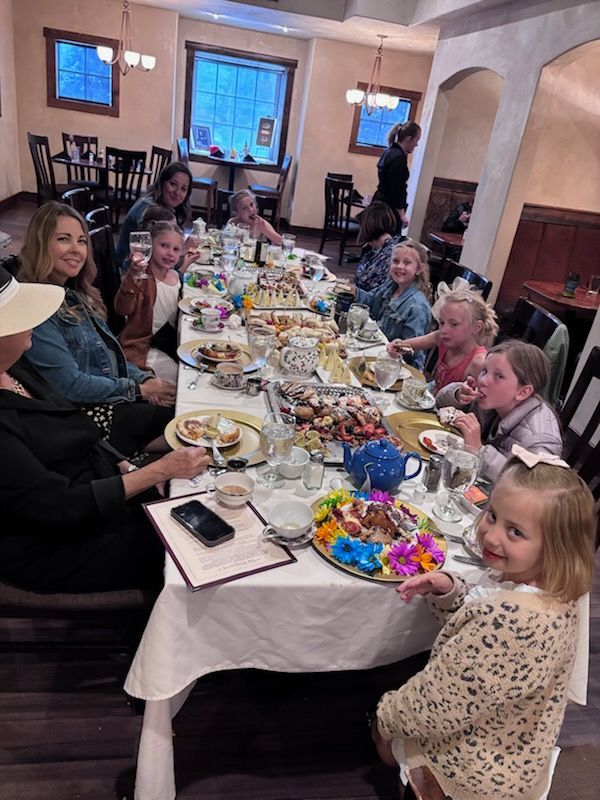 Group of people, mostly girls, at a long table set for a party in a restaurant. Smiles, food, drinks. Group of people, mostly girls, at a long table set for a party in a restaurant. Smiles, food, drinks.