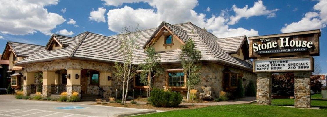 A large stone house with a sign in front of it.