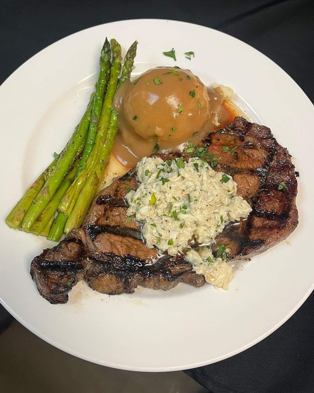 A White Plate Topped with A Steak , Mashed Potatoes and Asparagus.