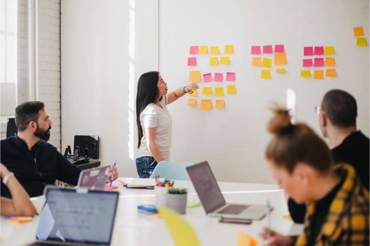 A woman is giving a presentation to a group of people in a conference room.